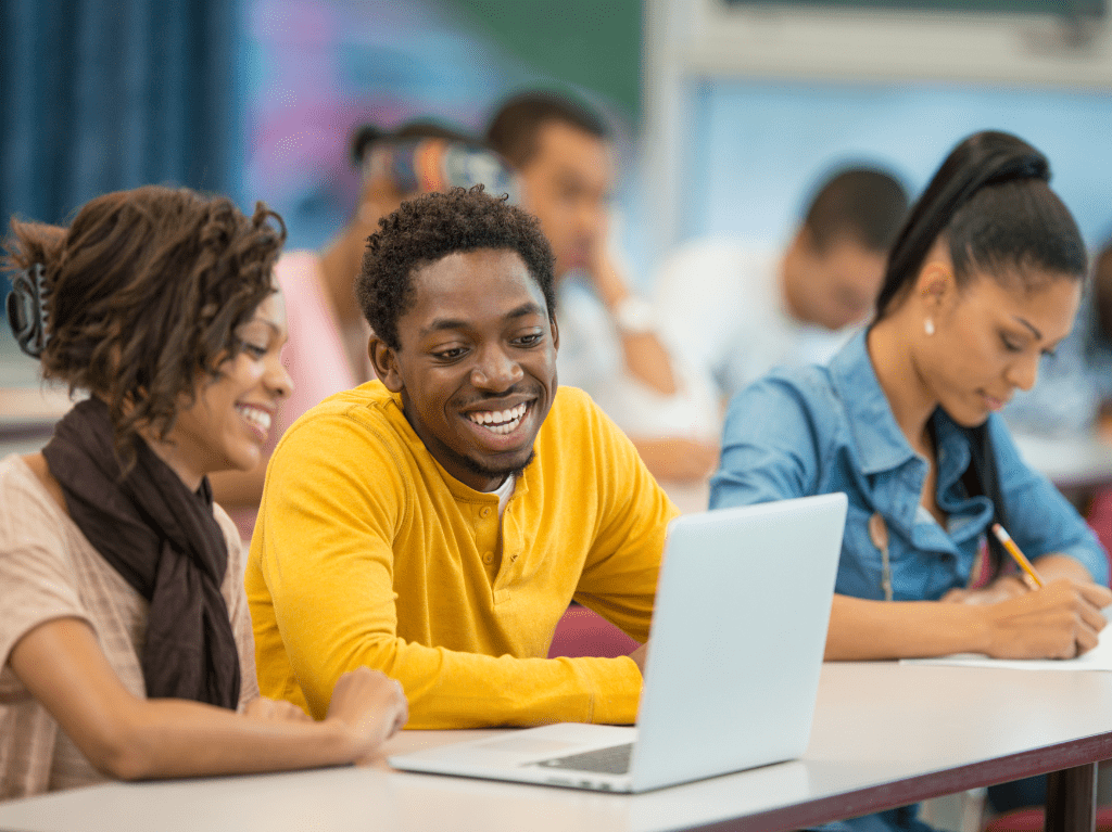 College students working together on a laptop.