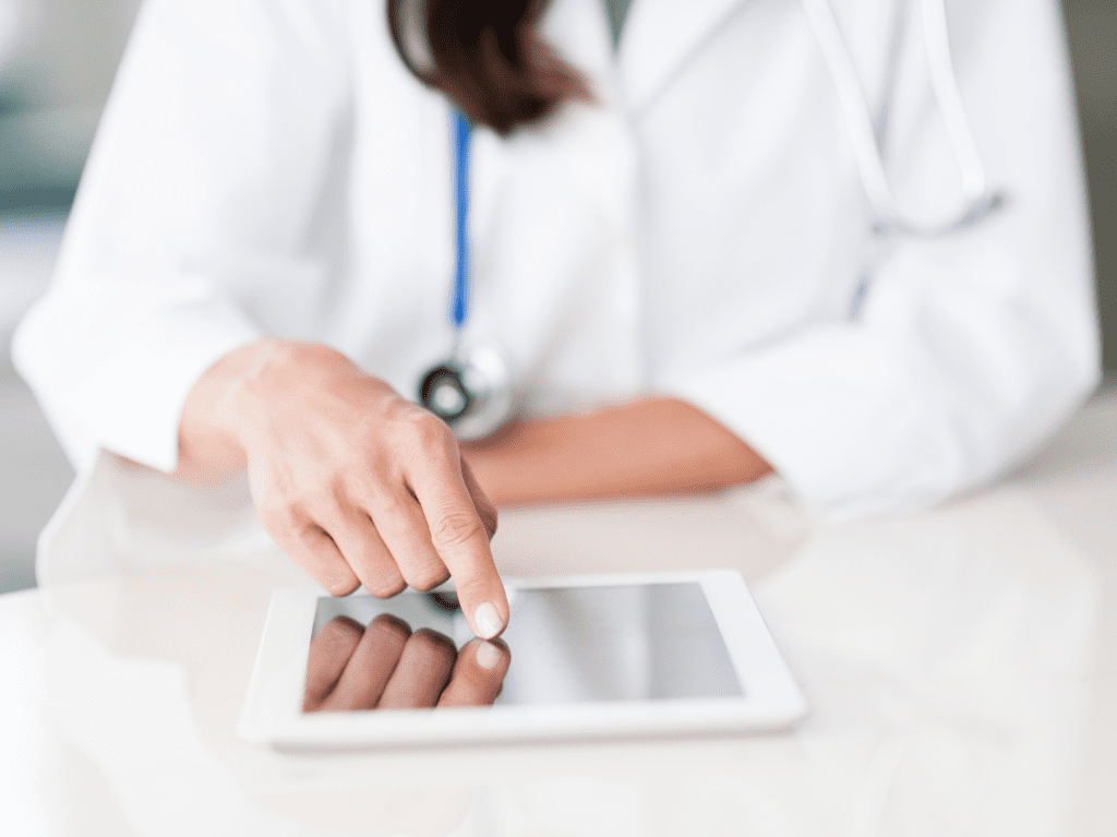 A medical professional getting help using a tablet.