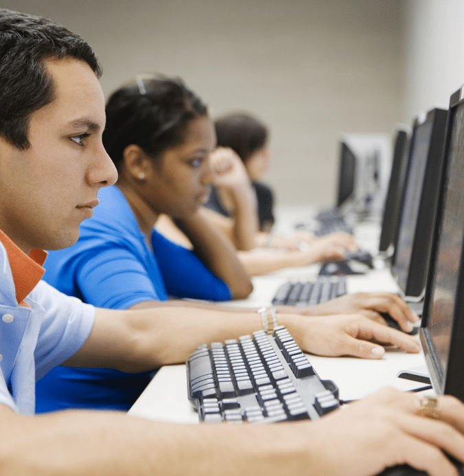 College students sitting in the computer lab all looking at their monitors.