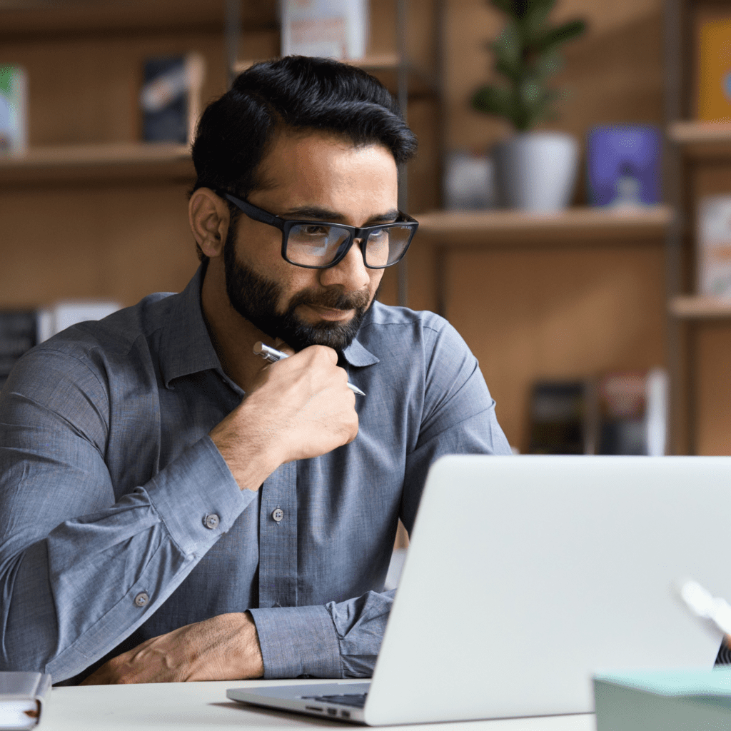 Man sitting at desk watching a webinar featuring IT experts.